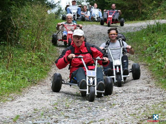 eine-gruppe-aus-mehreren-personen-f-hrt-mit-mountaincarts-fahrzeugen-mit-drei-r-dern-und-einem-lenke
